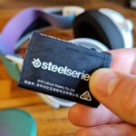 SteelSeries headset swappable battery held in fingers close-up