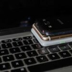 Three smartphones piled on a laptop keyboard